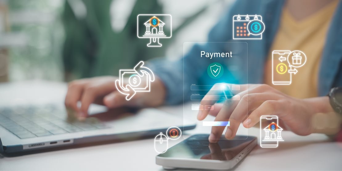 Person using a laptop and smartphone with digital payment and banking icons overlayed, representing online payment systems and financial technology.