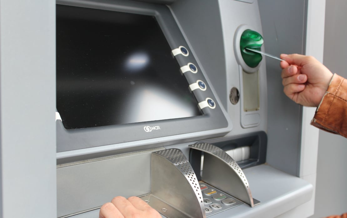 A person using an ATM to symbolize how end-to-end testing and VirtualATM help validate workflows, reduce errors, and keep ATM operations running smoothly